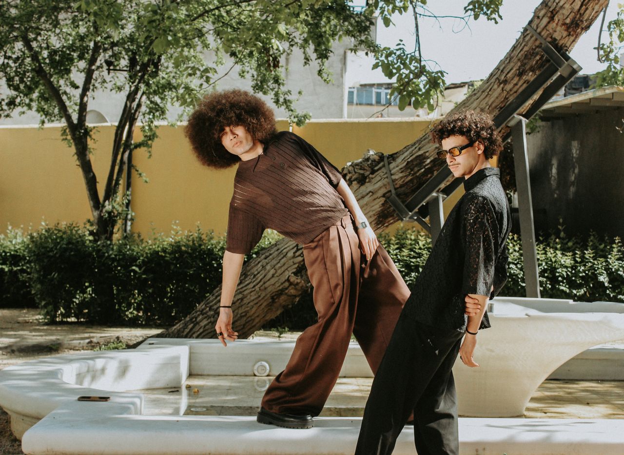 hero-img-02 Stylish young men striking a pose outdoors with a vintage aesthetic.