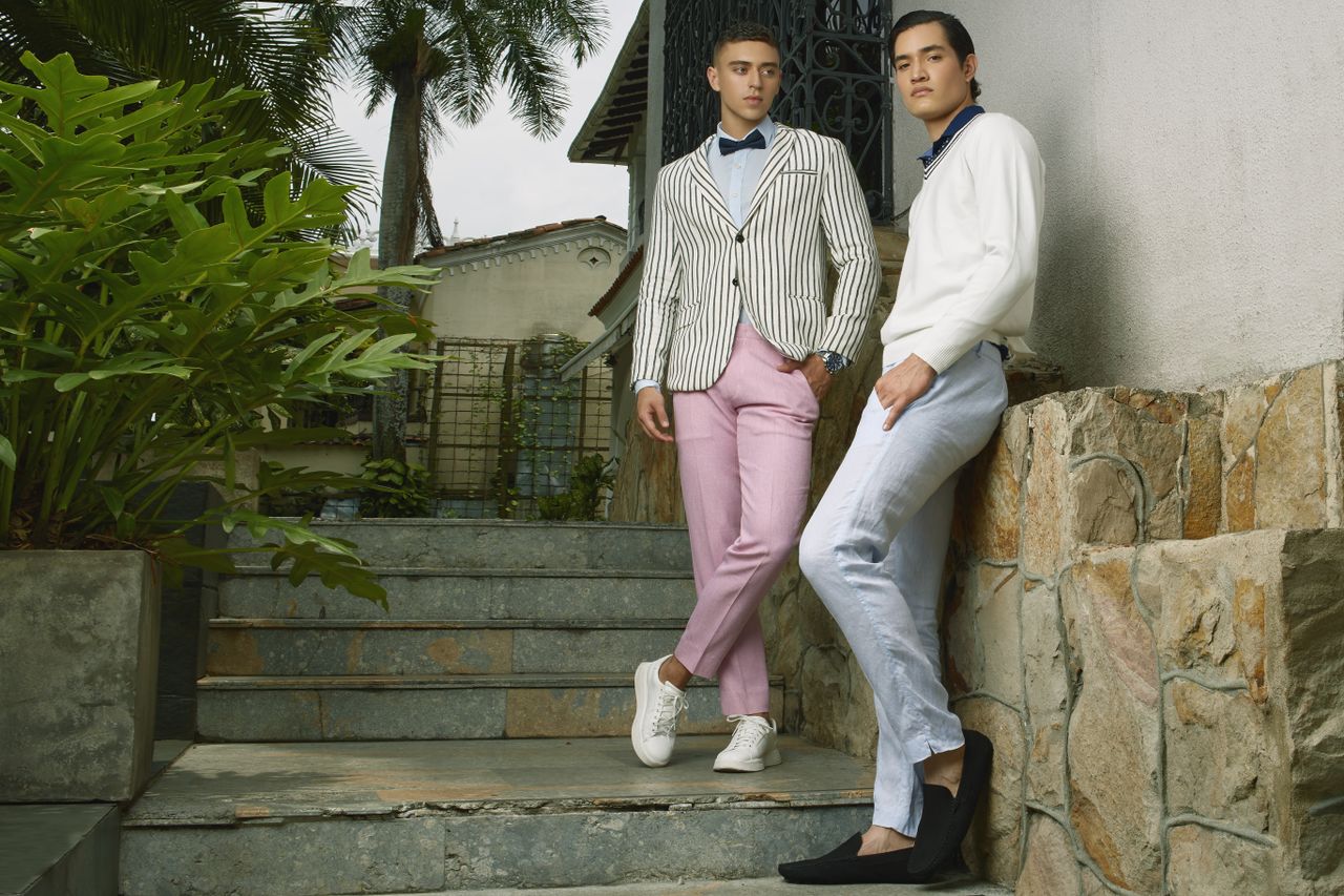 why-choose-us Two stylish young men posing in fashionable attire in an outdoor setting in Colombia.